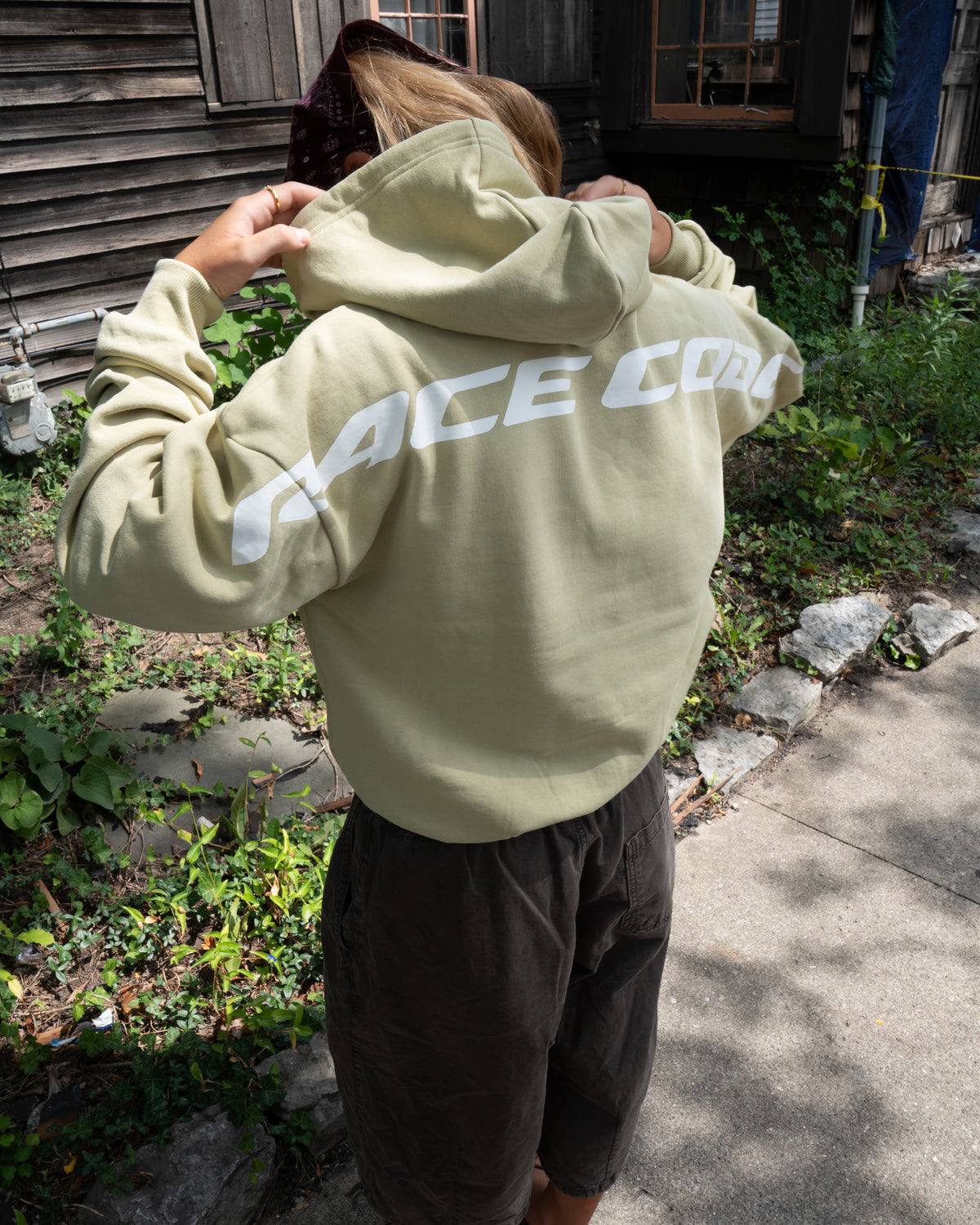 Woman wearing the Circuit Club Khaki Hoodie, back detail