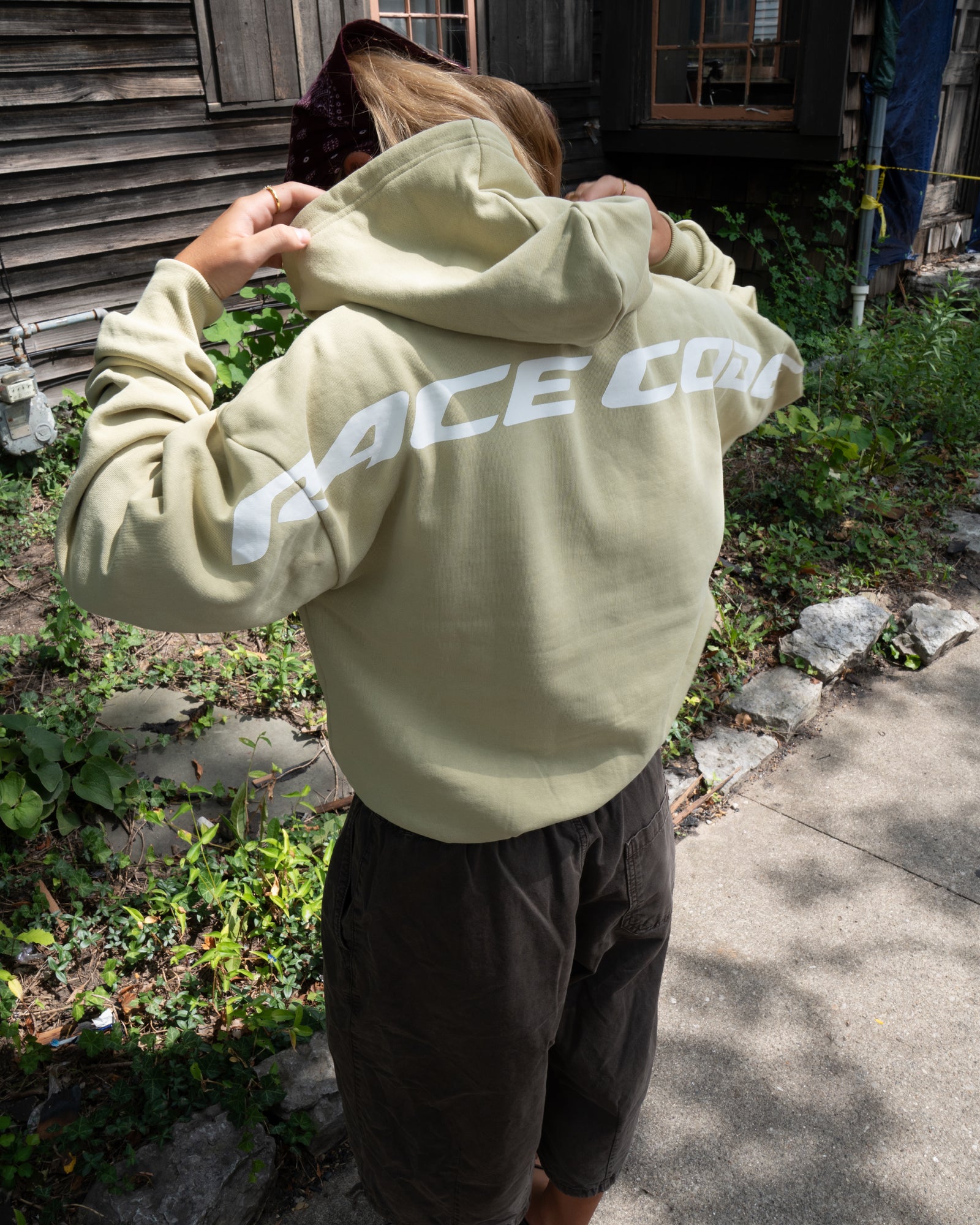 Woman wearing the Circuit Club Khaki Hoodie, back detail