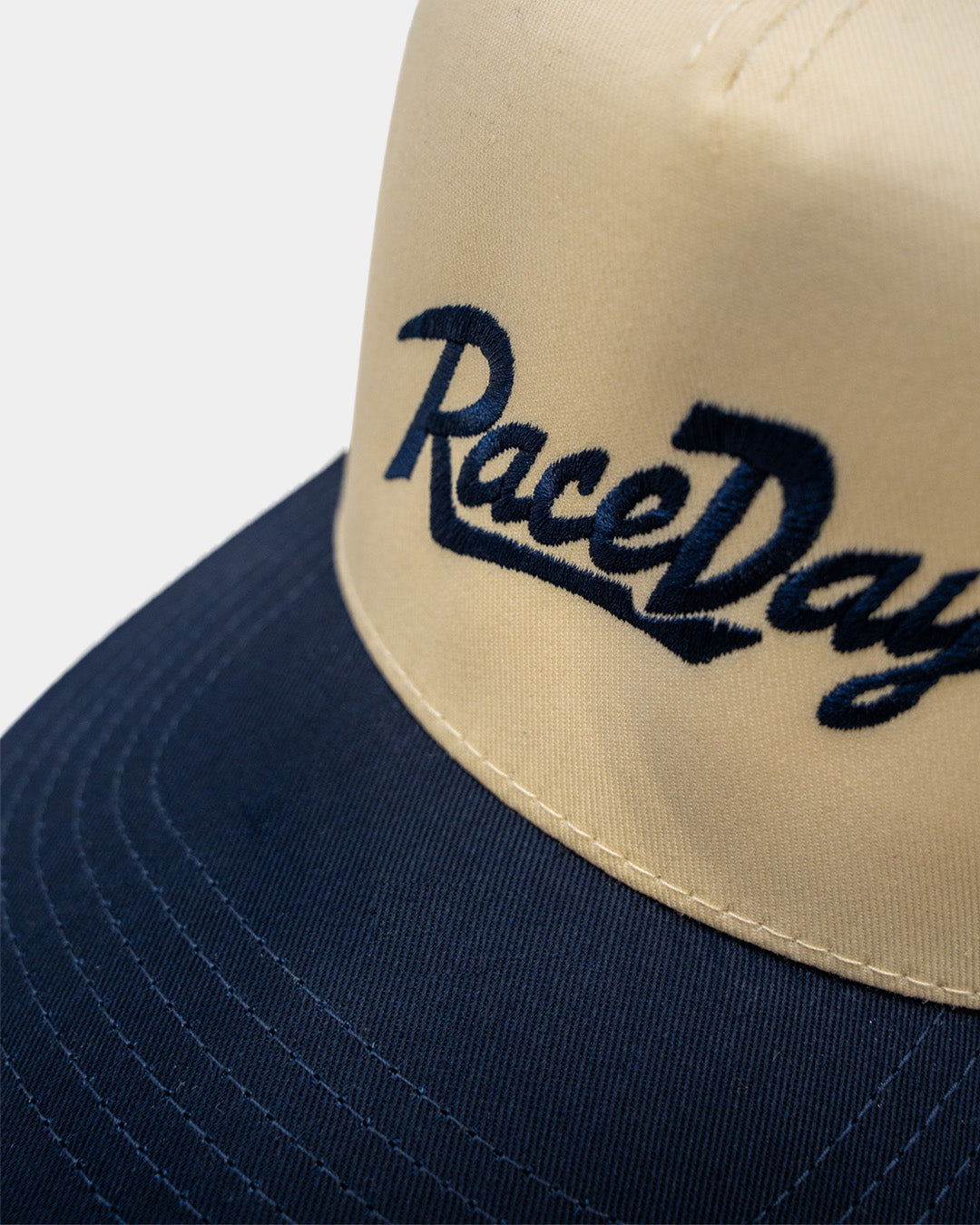Detalle del bordado RaceDay en cursiva azul marino de la RaceDay Hat Navy