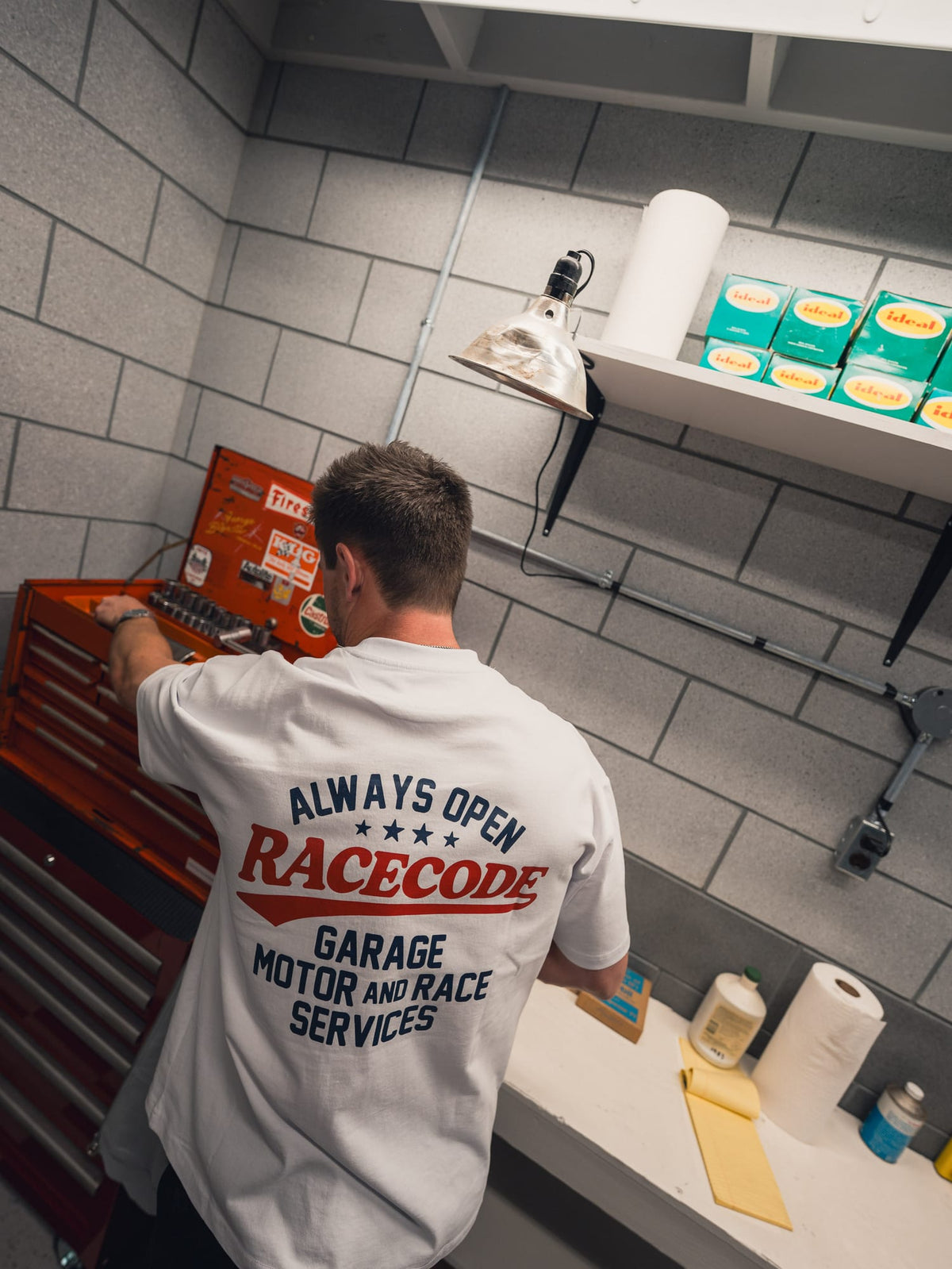 Garage Tee White worn from the back at a red tool chest in the garage, Always Open print