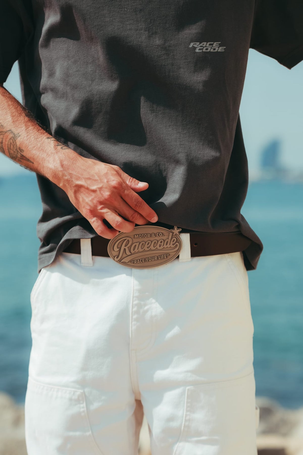 Cowboy Belt worn with a dark grey tee and white trousers by the sea