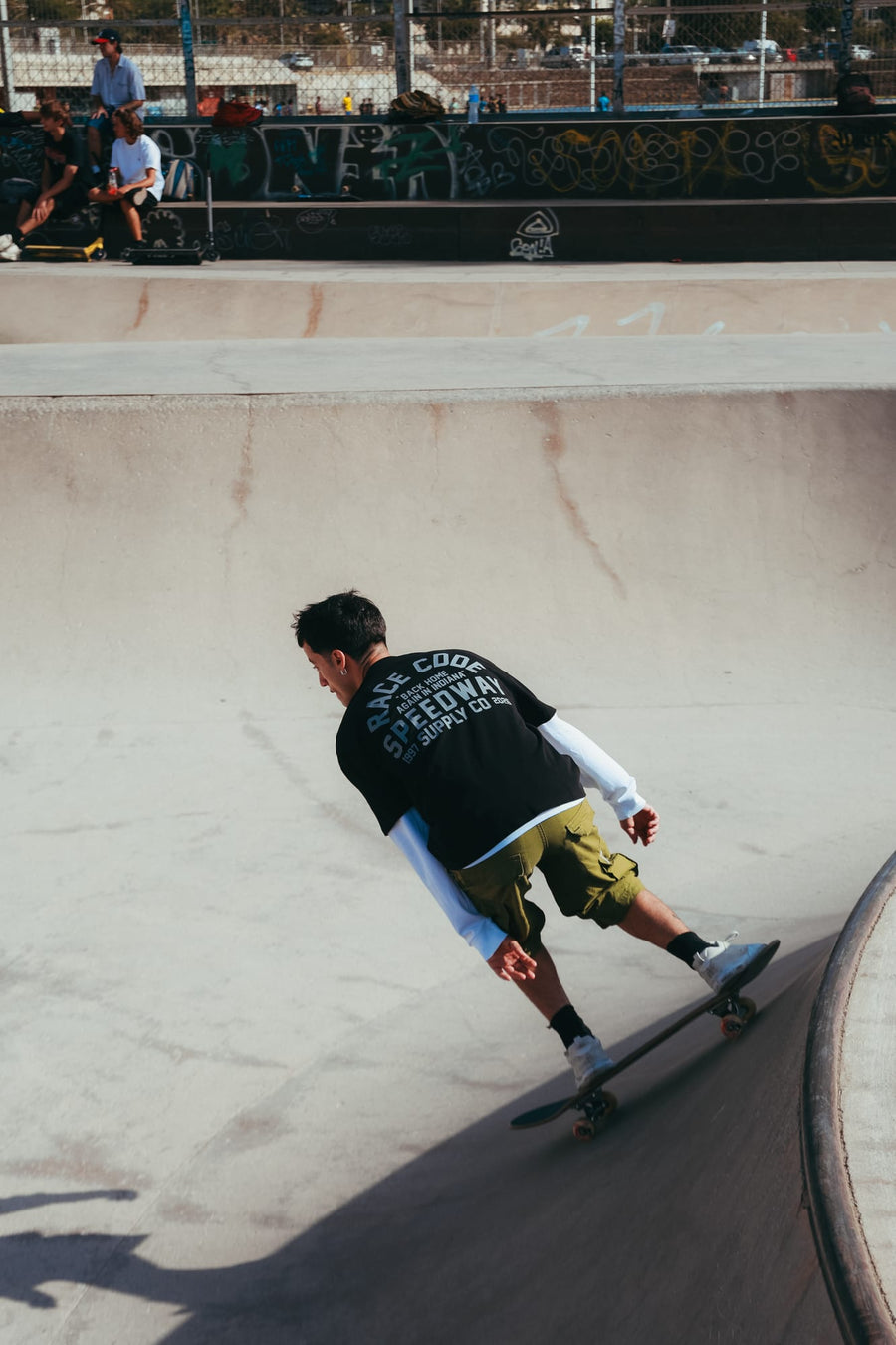 Skater con la Speedway Tee Black, vista trasera en un skatepark
